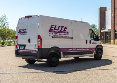 Rear three-quarter view of an Elite Transportation Systems high-roof sprinter cargo van in a parking lot