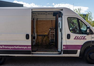 Side door open on an Elite Transportation Systems sprinter van showing the hand truck and cargo bay