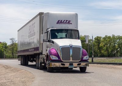 Head-on view of an Elite Transportation Systems Kenworth day cab pulling a dry van trailer