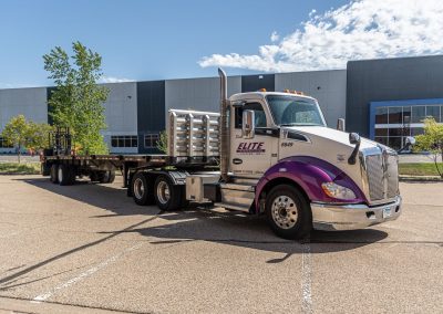 Elite Transportation Systems semi flatbed parked outside an industrial building